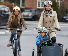 Mor der cykler med barn i ladcykel